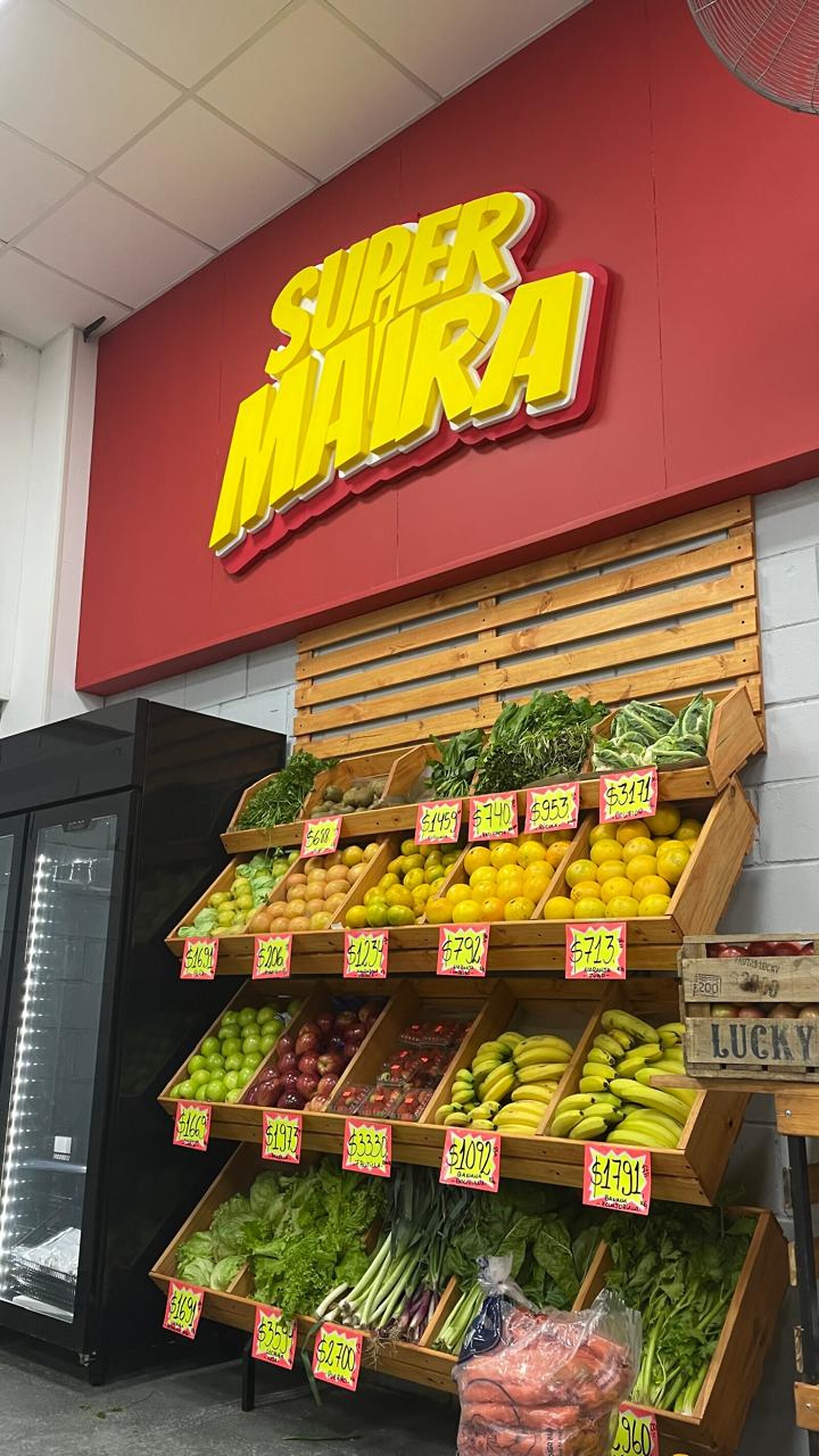 Cartel SuperMaira sobre la góndola de frutas y verduras